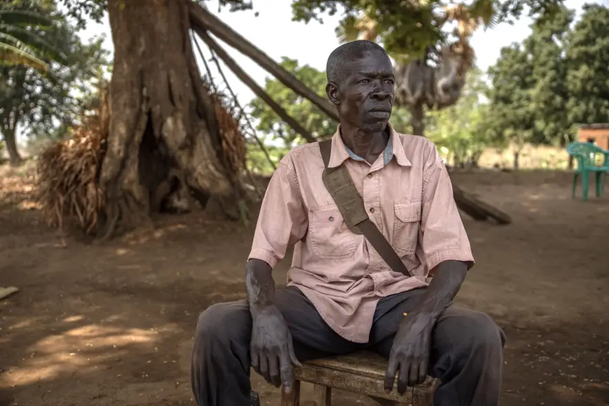 Ratib Embaga, 59, outside his home in Barakala, near the border of Bidibidi Refugee Settlement in Yumbe District, Uganda, on March 5, 2026. A farmer and landowner, Ratib has dedicated himself to promoting peaceful coexistence between refugees and the host community while supporting local agricultural initiatives.Previously part of the HEKS farmers group project, Ratib now serves as chairperson of the Peace Forum in Barakala Town Council, Romogi Subcounty. He has allowed refugees to cultivate part of his land rent-free for five years and advocates for other landowners to do the same, fostering cooperation, economic opportunity, and harmony between refugee and host communities.